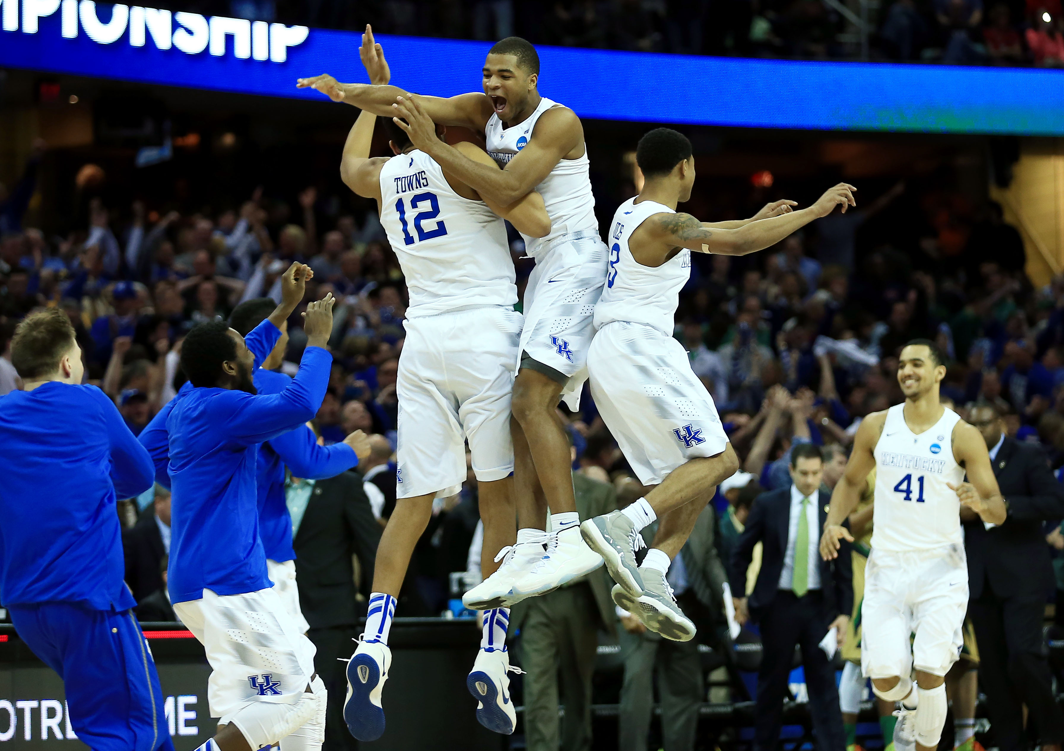 Mar 28, 2015; Cleveland, OH, USA; Kentucky Wildcats forward Karl-Anthony Towns (12) and guard Aaron Harrison (2) and guard Tyler Ulis (3) jump in the air after the game against the Notre Dame Fighting Irish in the finals of the midwest regional of the 2015 NCAA Tournament at Quicken Loans Arena. Kentucky won 68-66. Mandatory Credit: Andrew Weber-USA TODAY Sports