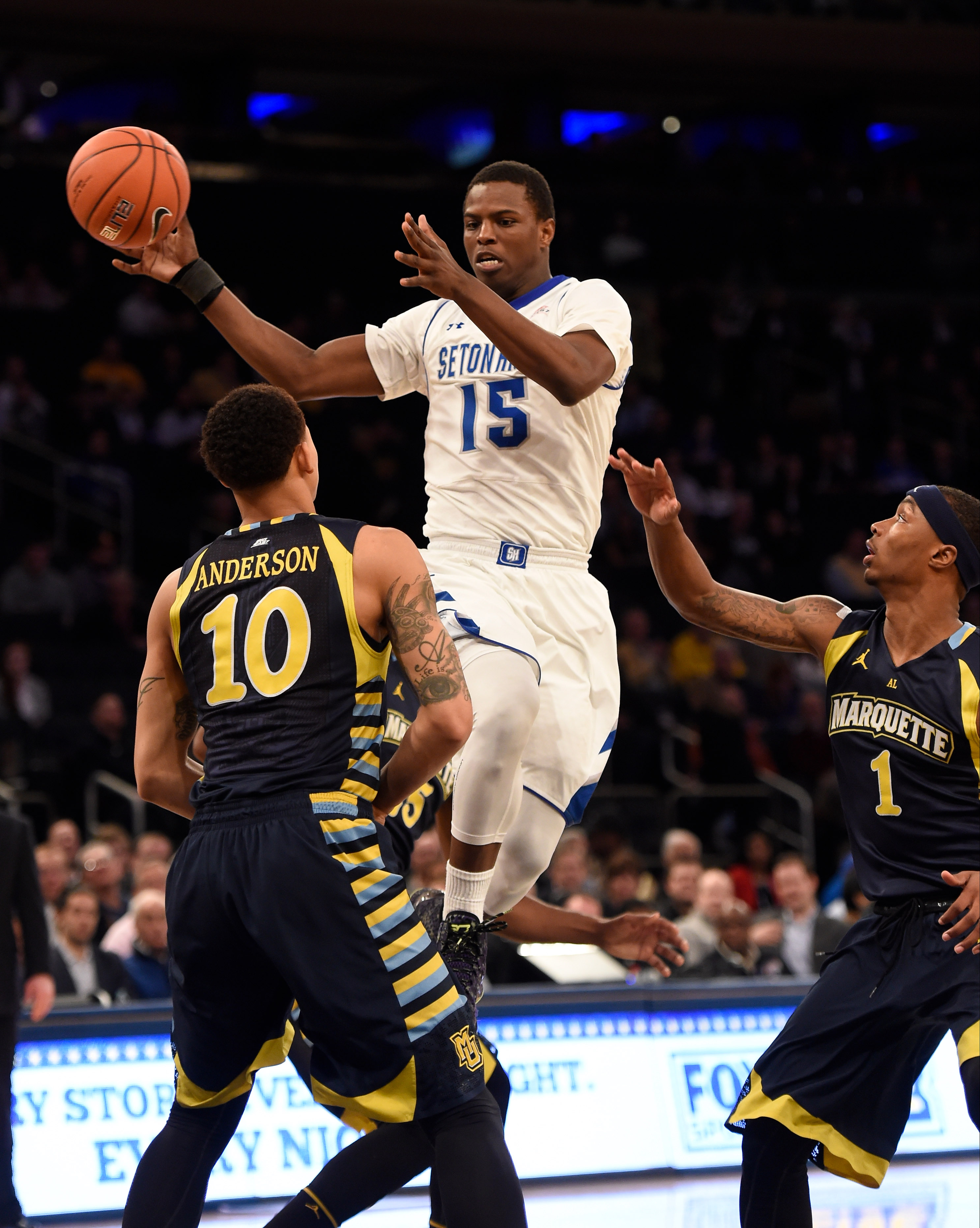 Mar 11, 2015; New York, NY, USA; Seton Hall Pirates guard Isaiah Whitehead (15) passes off over Marquette Golden Eagles forward Juan Anderson (10) during the first round of the Big East Tournament at Madison Square Garden. Mandatory Credit: Robert Deutsch-USA TODAY Sports